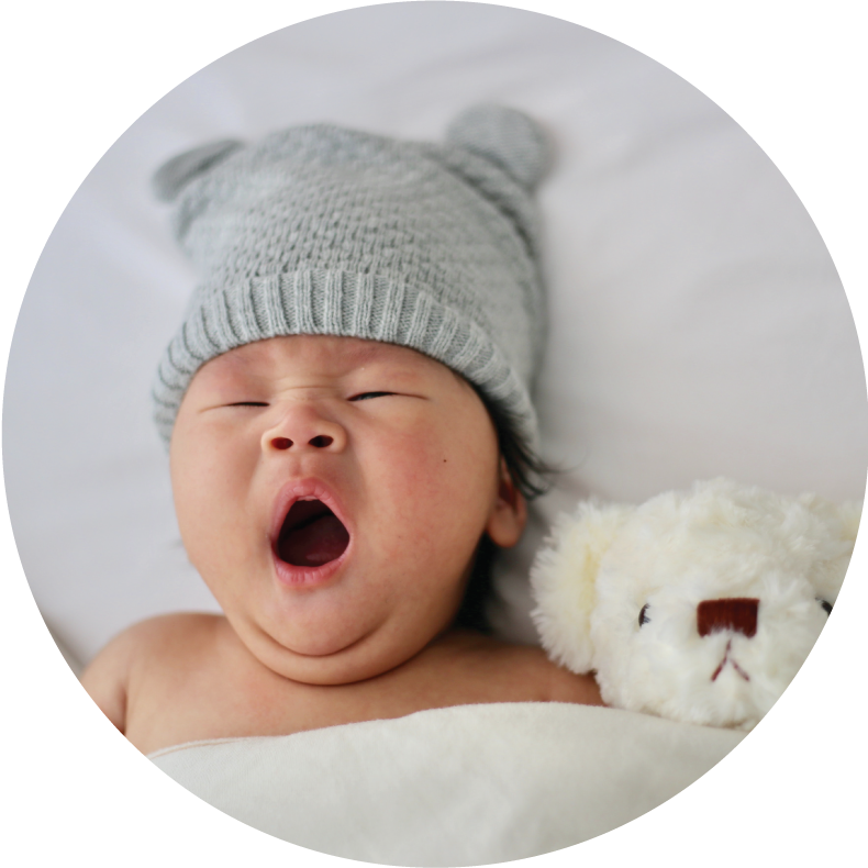 A yawning baby with a teddy bear